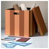 Brown TJENA cardboard box with handle. Holds office supplies. Sturdy.