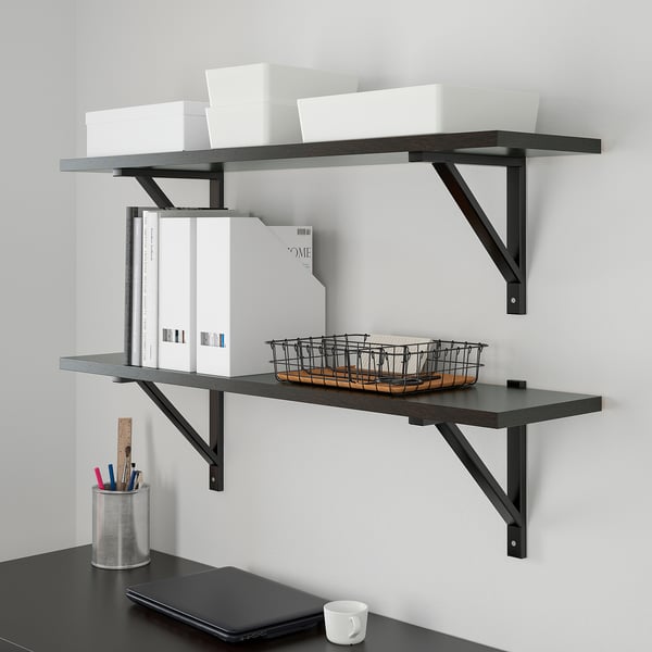 Wall-mounted shelves with TJENA storage boxes and desk organizers. Includes pen holder, books, and basket for tidy workspace.