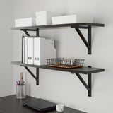 Wall-mounted shelves with TJENA storage boxes and desk organizers. Includes pen holder, books, and basket for tidy workspace.