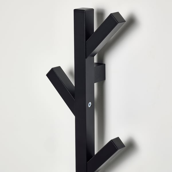 Black wooden coat rack with four hooks, mounted on a wall, showing sturdy construction and clean design for organizing clothes.