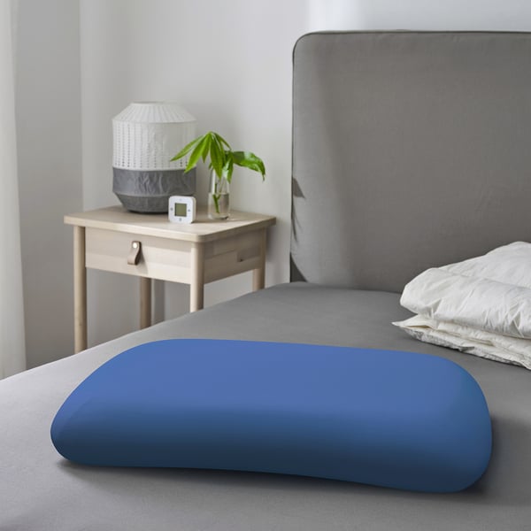 Blue TÖCKENFLY pillowcase on bed, cotton, grey bed, nightstand with lamp, plant, clock.