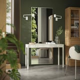 Modern green room with white TONSTAD desk, mirror, and chair. Wood and acrylic materials, minimalist design.