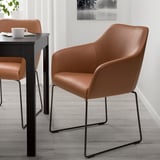 Two TOSSBERG chairs at black dining table, padded, space-efficient.