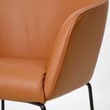 Close-up of tan leather chair showcasing soft, stitched upholstery and sturdy metal frame.