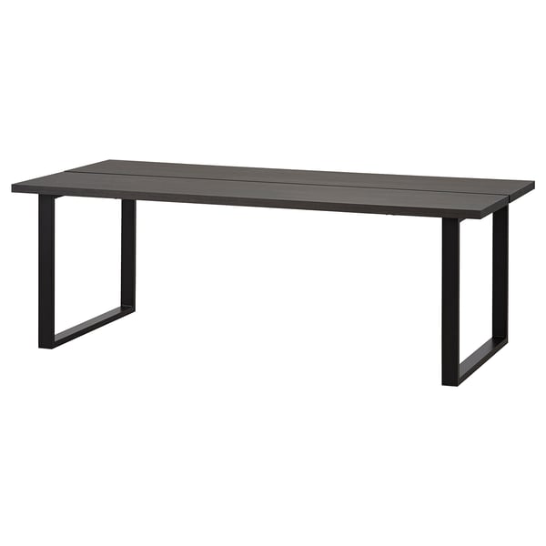 A TRANEBO dining table, black, rectangular, with a metal frame and laminate top. Modern industrial design.