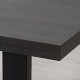 Modern black dining table with sleek, sturdy metal legs and smooth, durable tabletop surface.