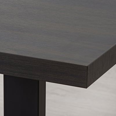 Close-up of sleek, dark TRANEBO table edge, showcasing smooth, durable melamine finish and sturdy frame.