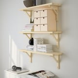 Wood shelves with books, boxes, plant, vase, headphones.