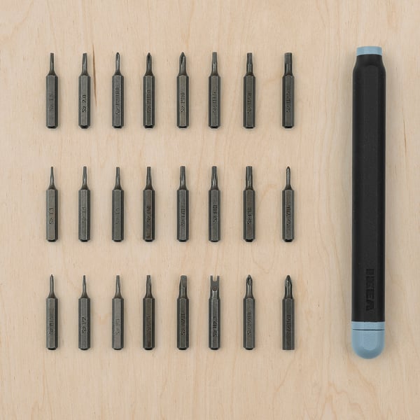 This image shows a TRIXIG black screwdriver set with blue caps laid out on wood. It includes various bits for different tasks.