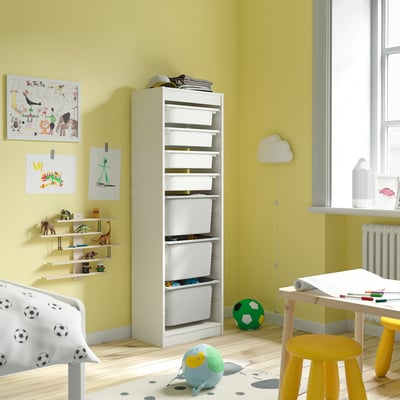 Yellow playroom with TROFAST storage, toys, stool, desk, wall decor.