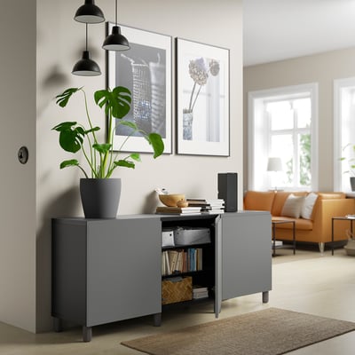 Modern living room with gray sideboard, storage, and plant.
