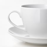 A pristine white porcelain cup with a smooth handle, reflecting quality and durability.