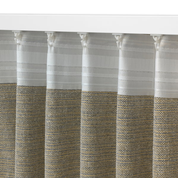 Close-up of luxurious, textured, grey curtains with intricate patterns and white hooks.