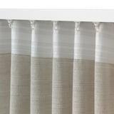 Close-up of textured curtain with horizontal stripes, secured with white hooks.