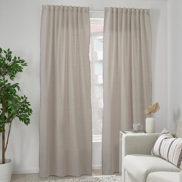Grey curtains with white fringes near white sofa, eco-friendly, recycled.