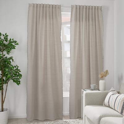 Grey curtains with white fringes near white sofa, eco-friendly, recycled.