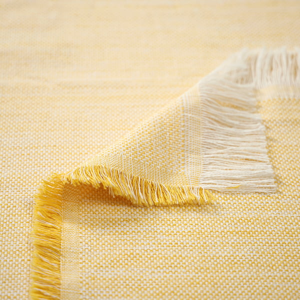 Yellow and white textured throw blanket with fringe edges, showcasing its soft and warm texture.