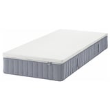 An IKEA VALEVÅG pocket spring mattress in white and grey with a memory foam top, designed for side sleepers or heavier back sleepers.