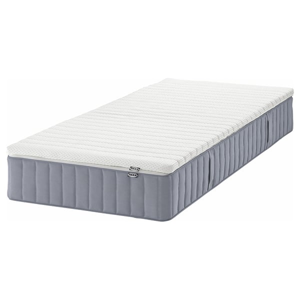 An IKEA VALEVÅG pocket spring mattress in white and gray, rectangular, with a quilted design and a removable cover.