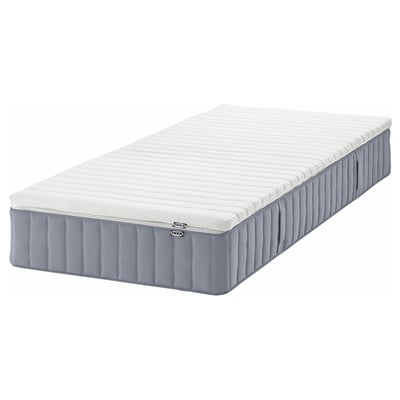 An IKEA VALEVÅG pocket spring mattress in white and grey, rectangular, with a quilted design and a removable cover.
