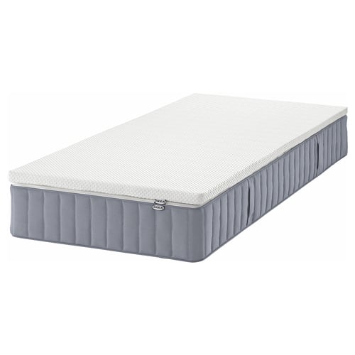 An ikea VALEVÅG pocket spring mattress, rectangular, in gray, with a textured surface for breathability.