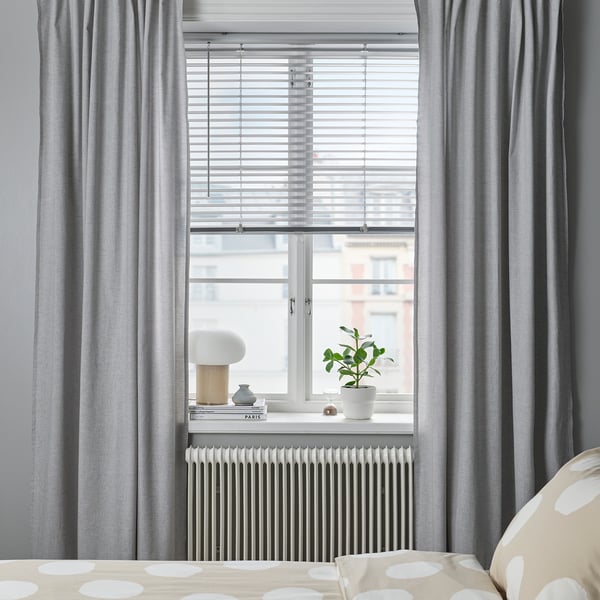 Modern bedroom with VECKLARFLY light gray blinds, polka dot bedding, potted plant, and decor on white radiator.