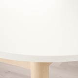 Modern dining table with sleek, matte white top and light wooden legs, evoking a clean and minimalist aesthetic.