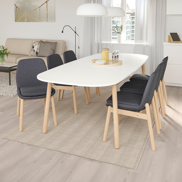 Modern dining set with white table, 4 grey chairs; sleek & sturdy, fits well in room.