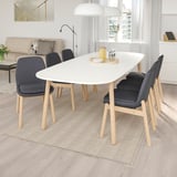 Modern dining set with white table, 4 grey chairs; sleek & sturdy, fits well in room.