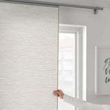 A hand adjusting VIDGA curtain panel holder, demonstrating easy curtain adjustments.