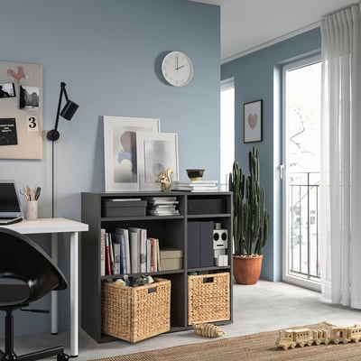 Modern blue home office with VIHALS dark gray storage unit, white desk, black chair, wall clock, and large window with white curtains.