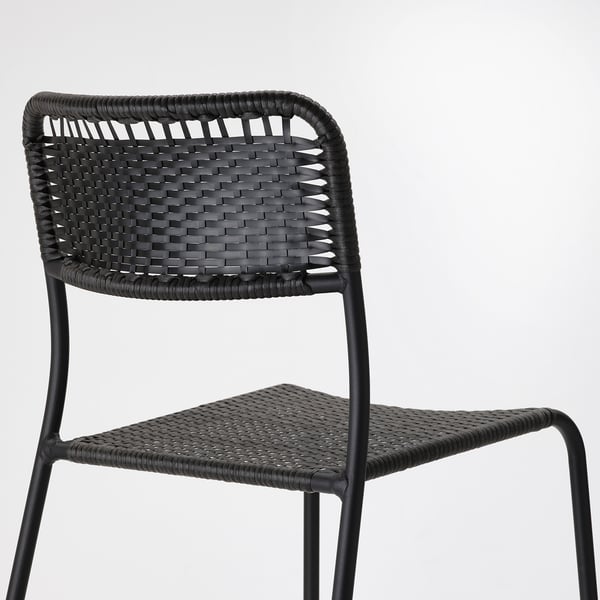 Black wicker chair with metal frame, showcasing intricate weave design and sturdy construction.