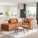 Modern living room: tan VIMLE sectional sofa with white pillows, black curtains, white rug, wooden tables, grey throw, plants, and globe light.