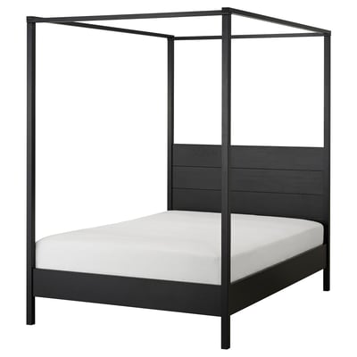 Black four-poster bed with wooden headboard and white mattress.