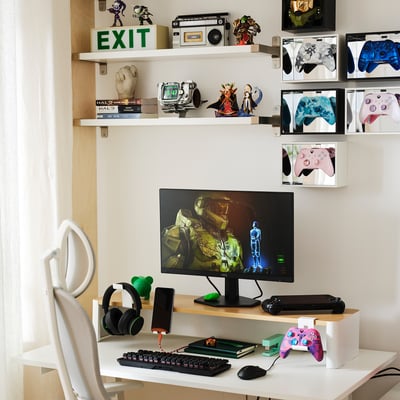 Gaming setup with monitor stand, controller display, and accessories.