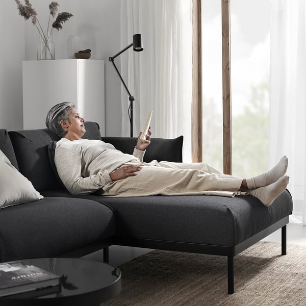Person ved hjælp af smartphone på moderne ÄPPLARYD sofa nær vindue.