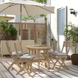 Terrassesæt i træ med bord, fire stole og hynder til kompakte rum.