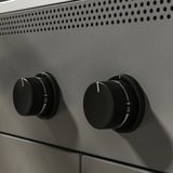 Moderne udekøkken med slankt design; Justerbare drejeknapper til præcis madlavningskontrol.
