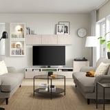 Stue: BERGSVIKEN tv-møbel, grå sofaer, glas sofabord, gulvlampe, vægur.