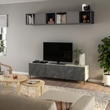 Moderne stue: gråt tv-bord, sorte hylder, beige sofa, træborde med drikkevarer, stor plante.