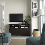 Moderne stue med BESTÅ tv-bænk, blå sofa og indrammede fotos.