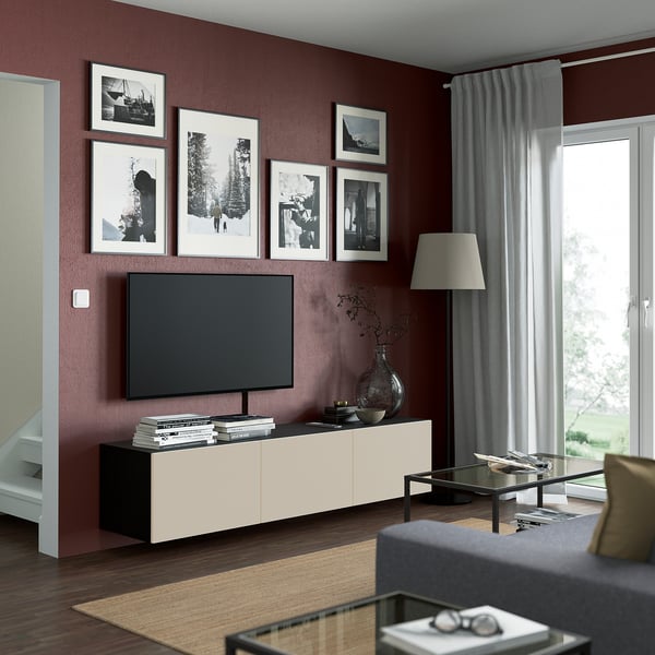 Moderne stue med fladskærms-tv på BESTÅ-enhed, mørkerød væg, fotos, opbevaring, lampe, vindue, sofabord, sofa.