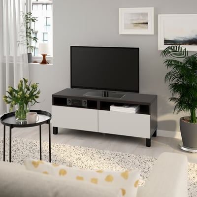 Moderne stue med BESTÅ tv-bænk, fladskærms-tv, blomster og plante. Rene skuffer og kabelhåndtering.