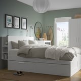Moderne soveværelse med BRIMNES seng, hvid kommode og garderobe. Sengen har opbevaring, plads i beroligende grønt med naturligt lys.