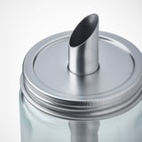 Cylindrisk glasflaske med hætte og tud i rustfrit stål. Låget skrues godt fast, hælder kontrolleret mængde.
