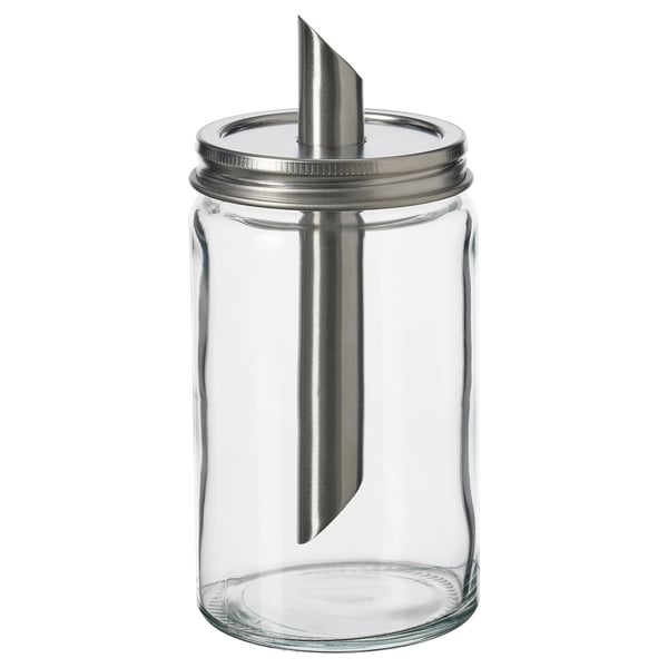 En tom, gennemsigtig sukkerbøsse i glas med låg i rustfrit stål og et metalrør, designet af IKEA.