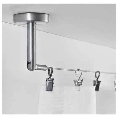 En sølv loftmonteret gardinstang med kroge og clips, der understøtter hvide gardiner, der demonstrerer dens anvendelse til ophængning og organisering af gardiner.