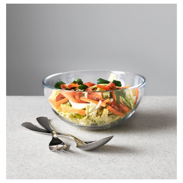 Glasskål med blandet salat med DRAGON gaffel og ske i rustfrit stål på hvid overflade.
