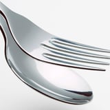 Nærbillede af poleret gaffel i rustfrit stål, der reflekterer lyset, og viser dens glatte, holdbare overflade.