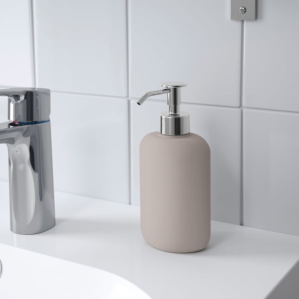 Sæbedispenser på en hvid vask, der afspejler moderne stil, passer sammen med andet tilbehør i EKOLN-serien.